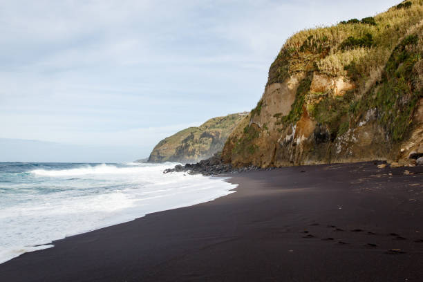 пляж черного песка на вулканическом острове - black sand beach hawaii islands maui стоковые фото и изображения