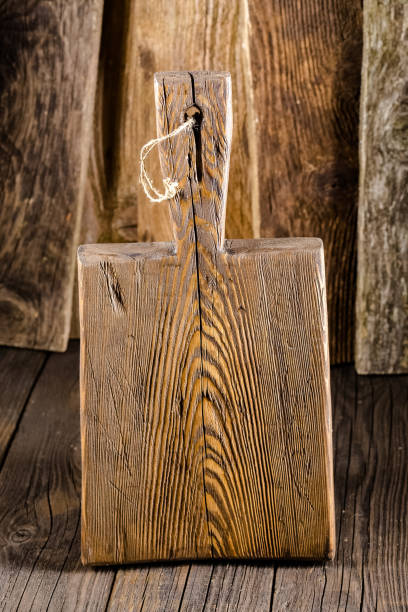 istock Russia, rustic old vintage wooden cutting board for the kitchen, with a groove structure, stripes, lies, stands on the table are cracks, black, brown, round square oval right angles sharp, rope 1148003395