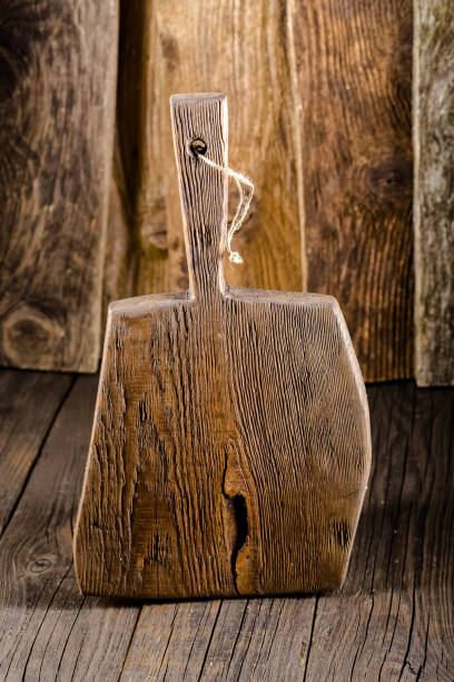 istock Russia, rustic old vintage wooden cutting board for the kitchen, with a groove structure, stripes, lies, stands on the table are cracks, black, brown, round square oval right angles sharp, rope 1148003440