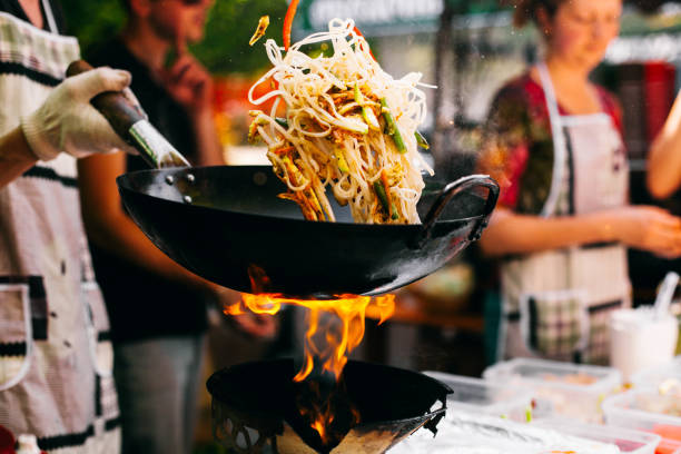 l’homme cuit des nouilles sur le feu - beef rice orange stir fried photos et images de collection