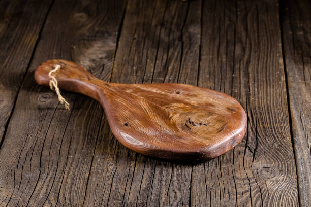 istock Russia, rustic old vintage wooden cutting board for the kitchen, with a groove structure, stripes, lies, stands on the table are cracks, black, brown, round square oval right angles sharp, rope 1148003677