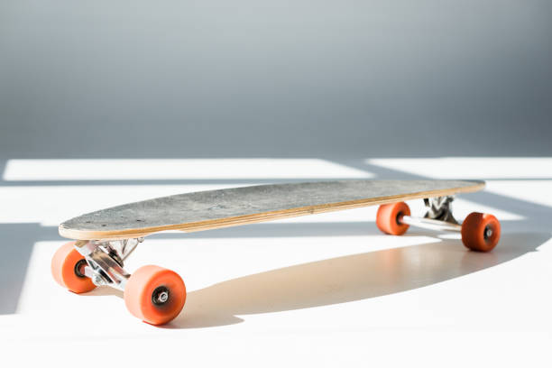 istock selective focus of longboard in sunlight with shadows on grey 1148004921