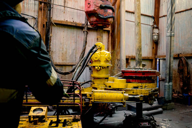 Offshore oil rig worker prepare tool and equipment for perforation oil and gas well at wellhead platform. Making up a drill pipe connection. A view for drill pipe connection from between the stands el trabajador offshore de la plataforma petrolífera prepara la herramienta y el equipo para la perforación del pozo de petróleo y gas en el pozo. haciendo una conexión de tubería de perforación. una vista para la conexión de tubería de perforación