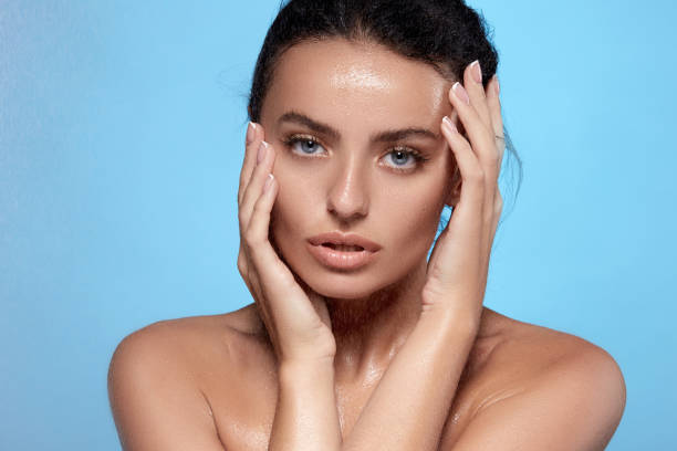istock sexy woman face with water splashes on blue background 1148006141