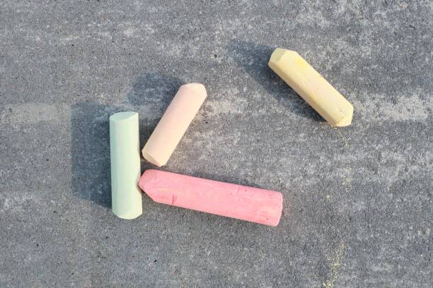Colored chalk on gray asphalt, top view