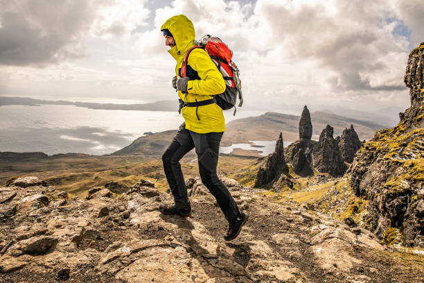 viajero solitario en old man of storr en escocia, isla de skye - rock pinnacle cliff mountain peak fotografías e imágenes de stock