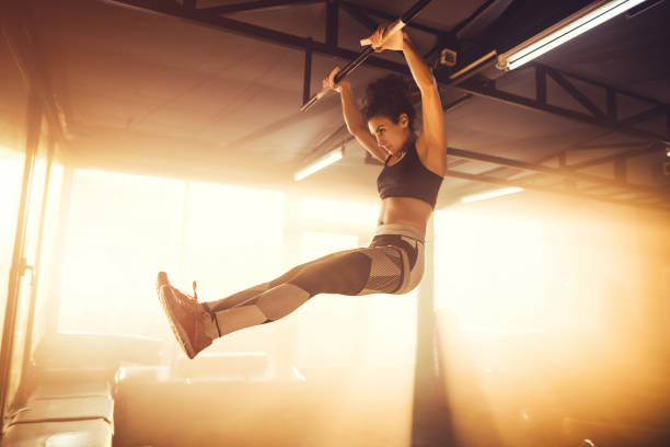 istock Young adult female doing chin-ups 1148009487