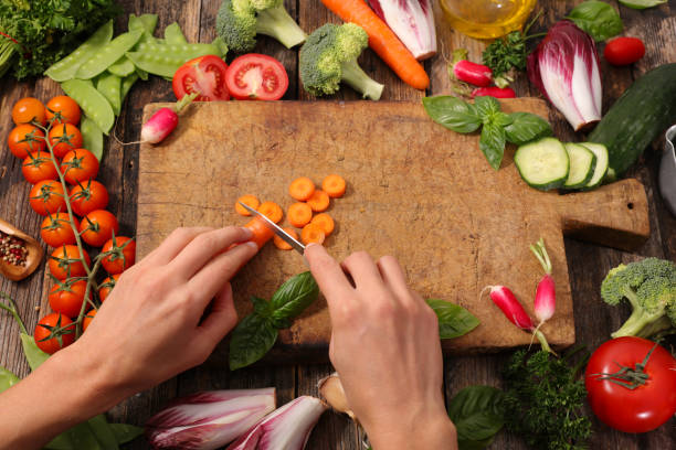 istock woman cooking, cutting raw vegetable on board 1148009599