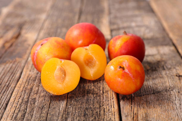 istock fresh plum on wood background 1148009614