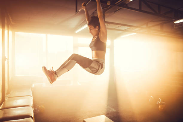 istock Young adult female doing chin-ups 1148009639