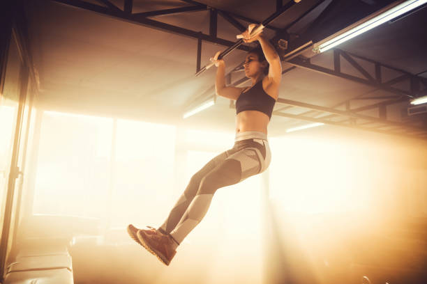 istock Young adult female doing chin-ups 1148010438