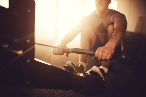 Close up of a man exercising on rowing machine. stock photo