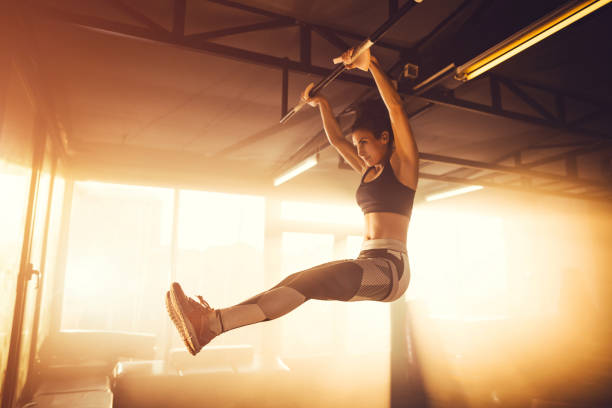 istock Young adult female doing chin-ups 1148010601