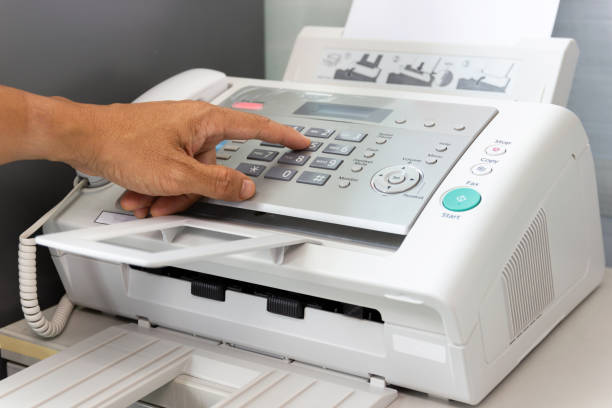 Hand man are using a fax machine in the office stock photo