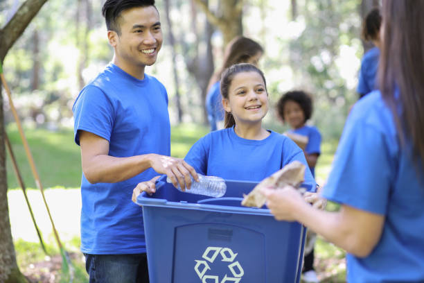 istock Environmental clean up. Volunteers pick up trash in local park. 1148010879