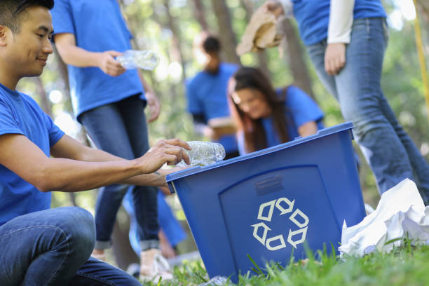 istock Environmental clean up. Volunteers pick up trash in local park. 1148010924