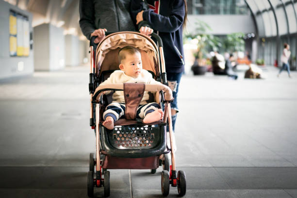 istock Couple Push Son Walk In The Park 1148013210