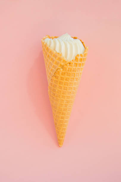istock Vanilla ice cream in waffle cone on pink background, copy space, vertical shot 1148013422