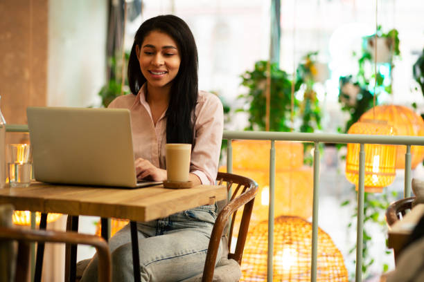 istock Dark haired student in casual clothes working on her laptop 1148014906