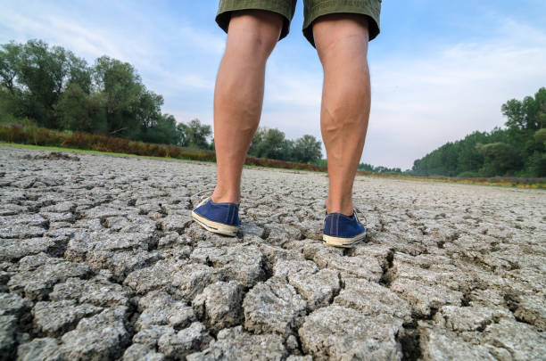 istock Man standing in the dry riverbed during drought 1148015155