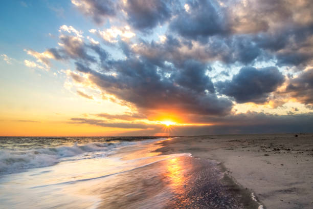 Warm golden light contrasts a stormy sky on the coastal scene.