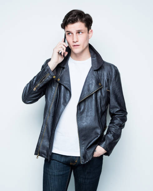 istock Close up view of attractive man wearing leather jacket and is using a smart phone 1148018184