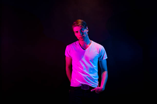 istock Attractive man standing in blue and red lights 1148021862