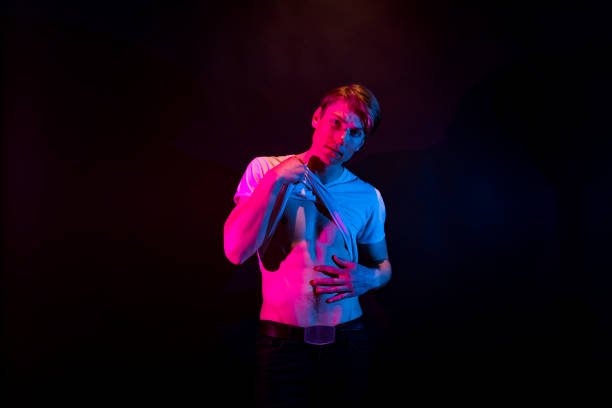 istock Sexy man in mood lighting undressing 1148021924