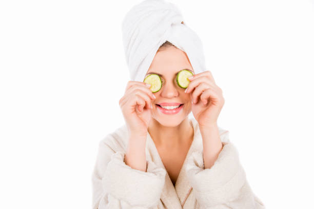 Pretty girl makes mask with cucumber slices