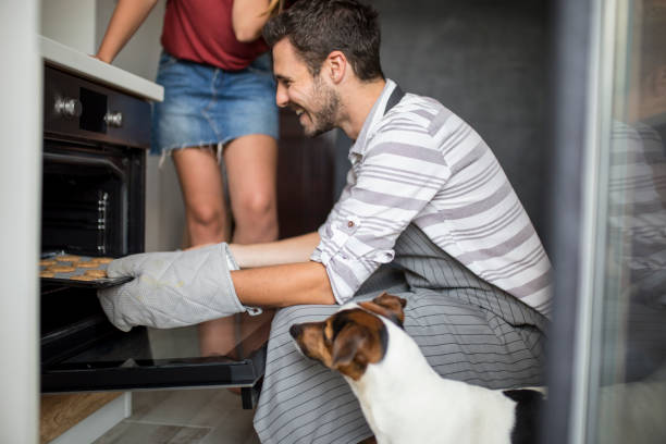 istock Young man checking food in oven low angle view 1148022943