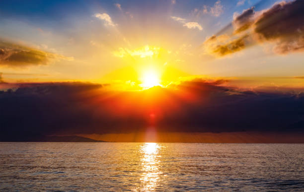 istock Red sunset over sea, rich in dark clouds, rays of light 1148024772