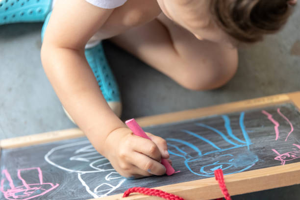 istock Three years old child little boy drawing in a blackboard 1148024844