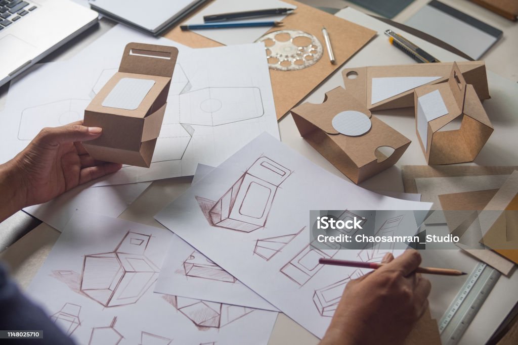Designer sketching drawing design Brown craft cardboard paper product eco packaging mockup box development template package branding Label . designer studio concept . Packaging Stock Photo