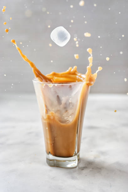 istock Iced coffee with splash on glass over grey background 1148029553