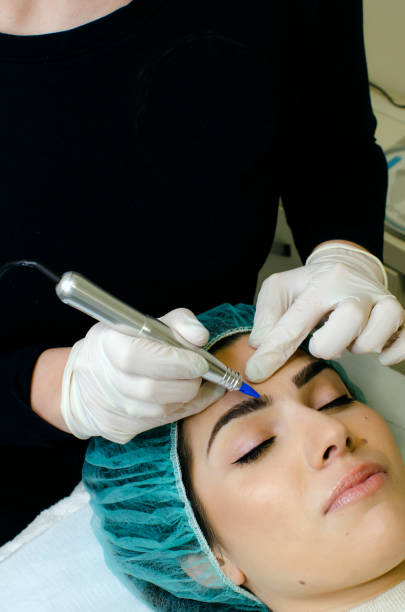 istock Beautician applying permanent make up on eyebrows in beauty salon 1148029619