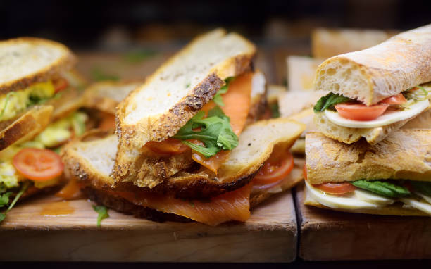 świeże kanapki na drewnianej desce do krojenia w oknie zakupy kawiarni lub restauracji - sandwich delicatessen bacon lettuce and tomato mayonnaise zdjęcia i obrazy z banku zdjęć