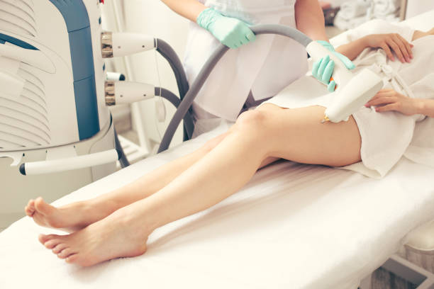 istock Legs of young lady and medical worker touching them with modern tool 1148033111