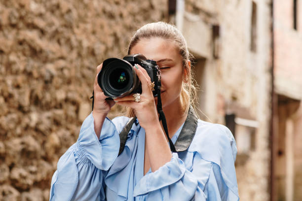 istock Young woman taking a picture with a DSLR camera 1148034913