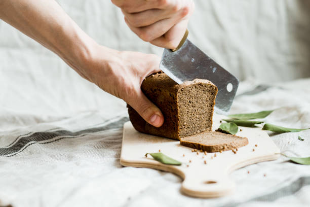 istock cutting with a knife freshly baked bread on a wooden Board 1148037622