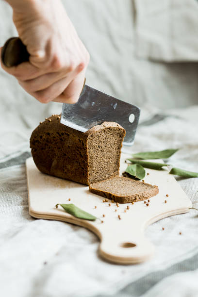 istock cutting with a knife freshly baked bread on a wooden Board 1148037673