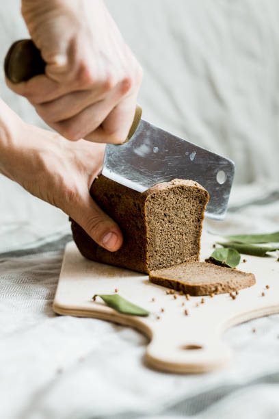 istock cutting with a knife freshly baked bread on a wooden Board 1148039042