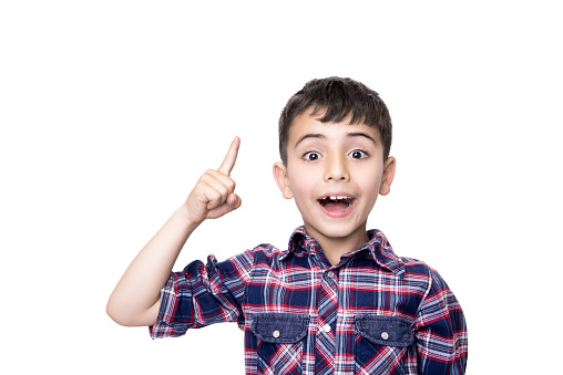 Portrait of a excited child pointing over white background. Horizontal composition. Studio shot.