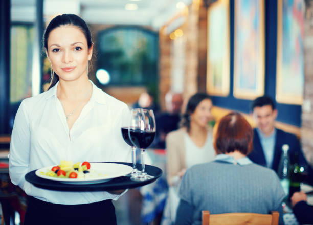 istock Professional waitress holding serving tray for restaurant guests 1148042208