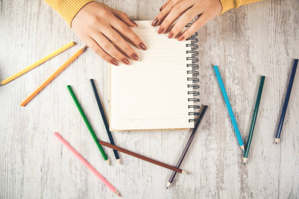 istock woman hand pencil with notepad on desk 1148043656