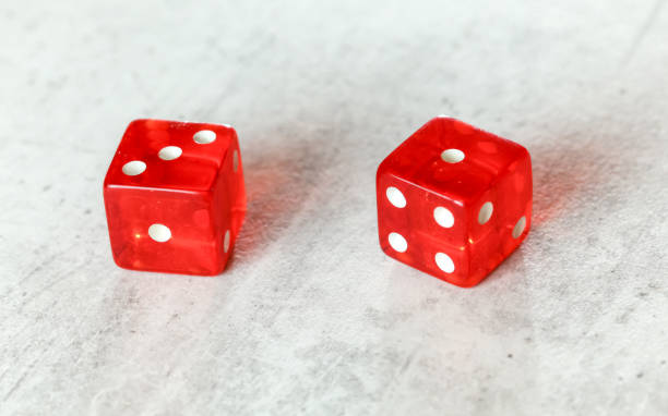istock Two translucent red craps dices on white board showing Easy Four number 3 and 1 1148046888