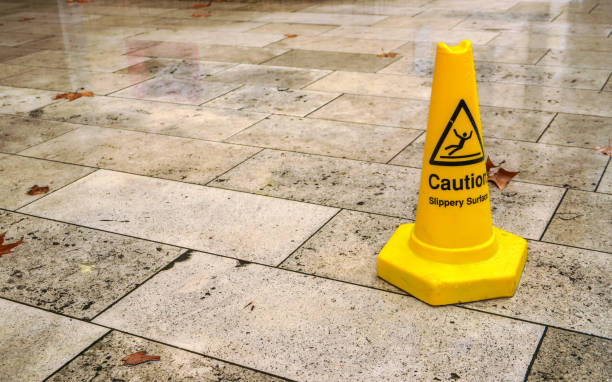 istock Yellow cone with caution slippery surface sign, on wet pavement tiles. 1148047818