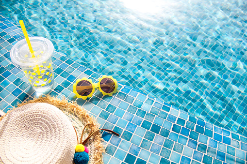 Summer vacation concept. Stylish yellow sunglasses, hat and fresh cocktail. Flat lay. Space for text. Time to travel