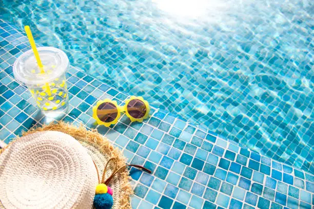 Photo of Summer vacation concept. Stylish yellow sunglasses, hat and fresh cocktail.