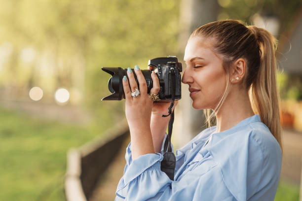istock Young woman taking a picture with a DSLR camera 1148048015