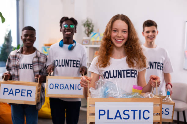 istock Girl holding box with plastic after sorting waste with friends 1148048165